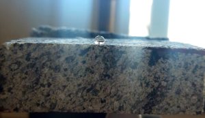 Goccia d’acqua su un provino di peperino trattato.