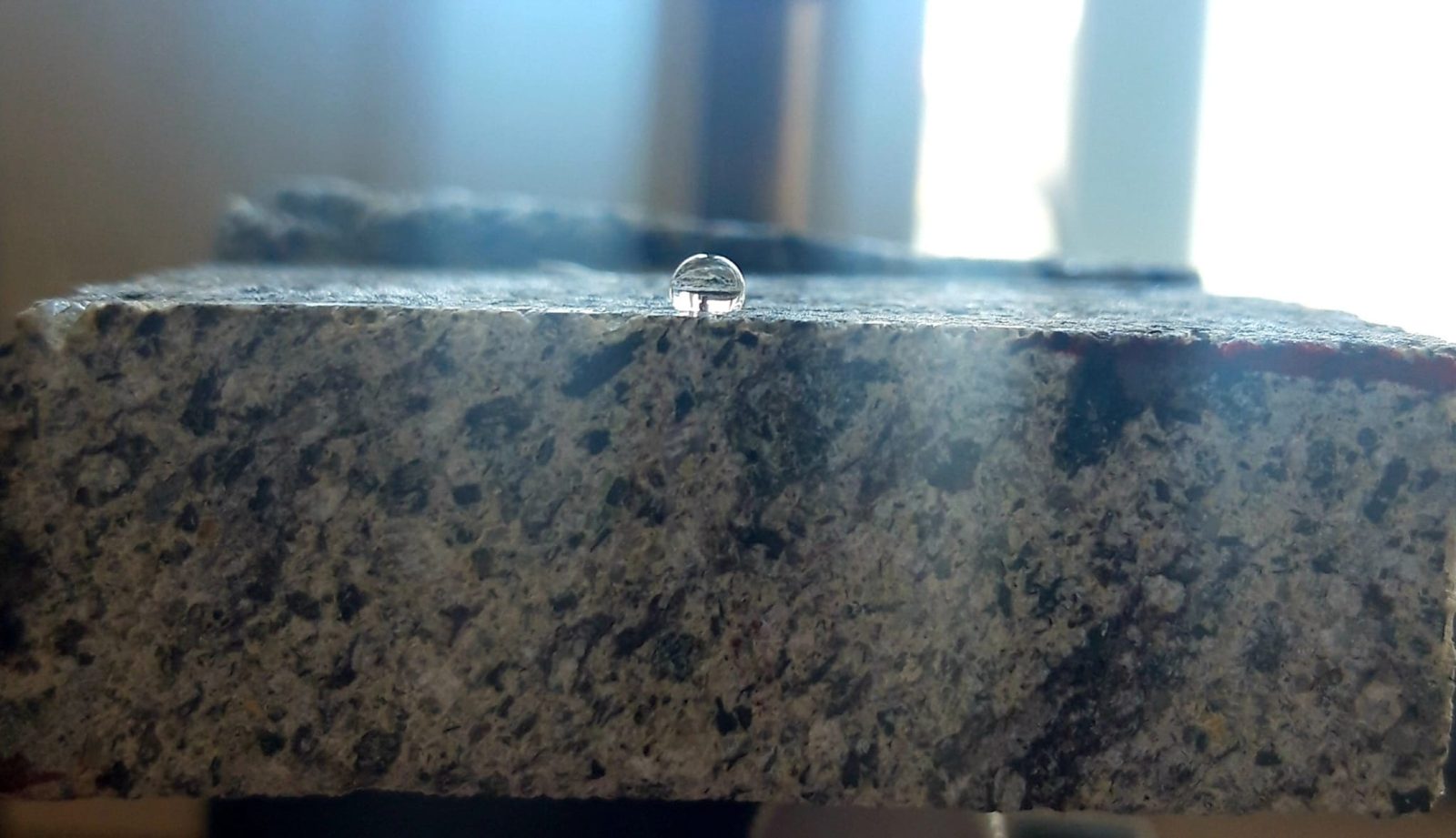 Goccia d’acqua su un provino di peperino trattato.