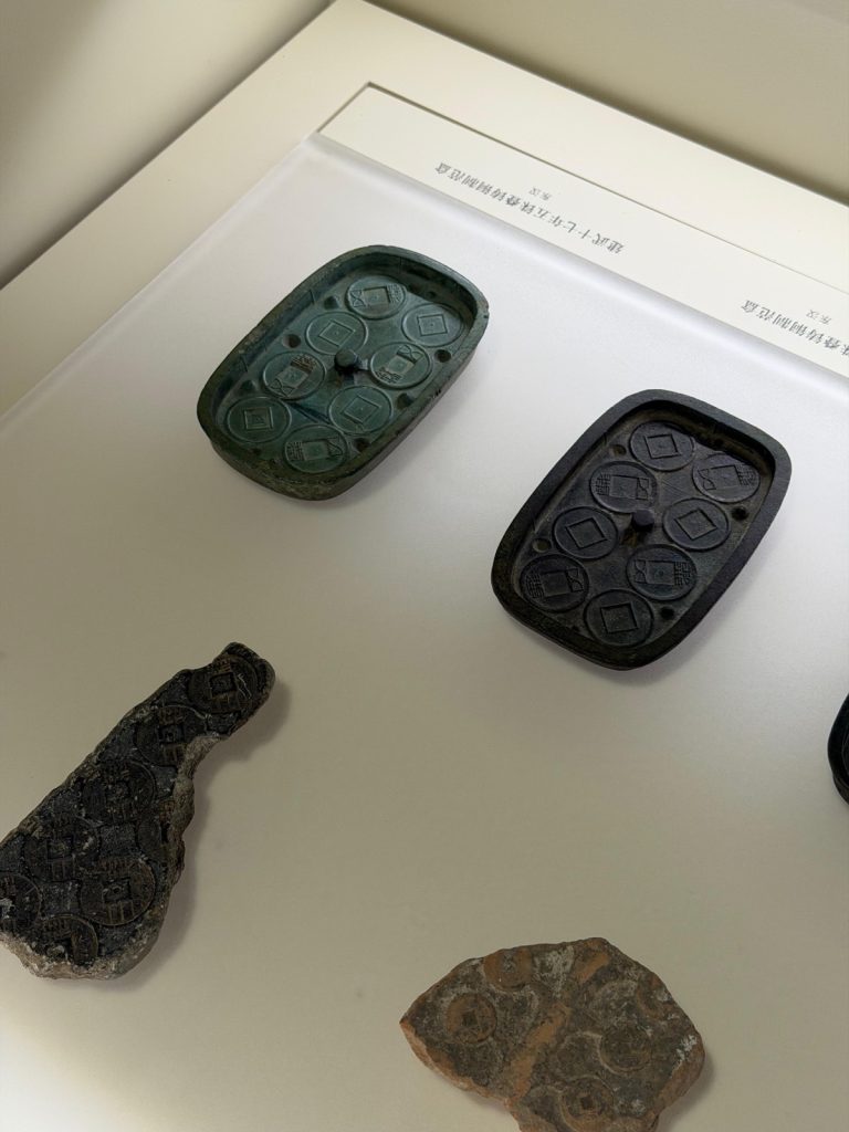 Matrici per monete antiche in una vetrina di museo.